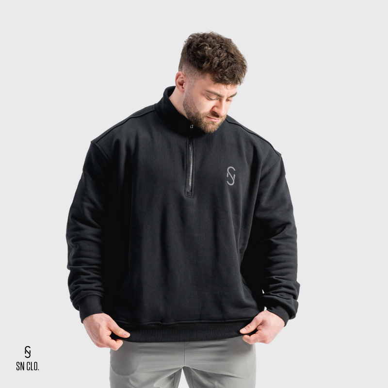 Man wearing a black 3/4 zip top with a SN Clo logo on a white background