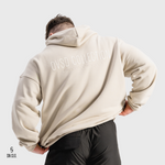 Person wearing a beige SN Clo. hoodie with 'OVSD Collection' text on the back, standing against a light grey background.