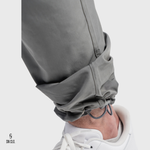 Close-up of a person wearing grey pants with a white background