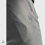 Close-up of a SN Clo. grey cargos with a zipper on the pocket and logo on a light grey background