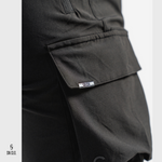 Black SN Clo. cargo shorts with a visible brand label on pocket on a light grey background