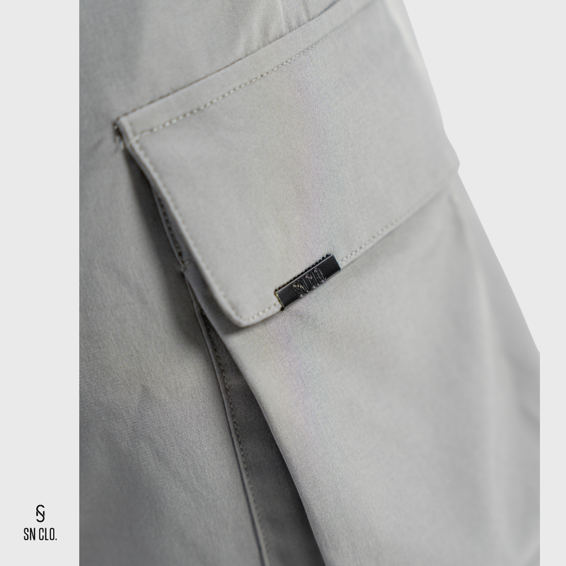 grey SN Clo. cargo shorts with a visible brand label on pocket on a light grey background