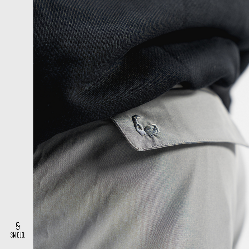Grey SN Clo. cargo shorts reverse pocket that contains embroidered bicep logo  